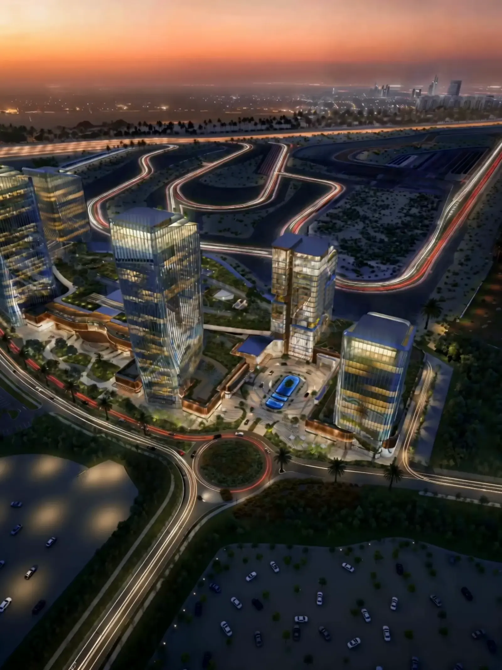 O1NE District office towers at dusk beside the Dubai Autodrome circuit